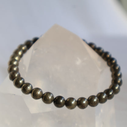 Pyrite 6mm bead stretch bracelet with metallic gold-toned beads and a natural reflective lustre.