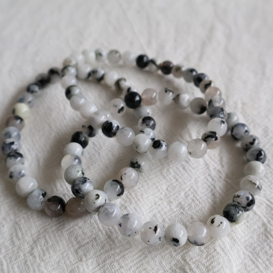 Natural Rainbow Moonstone 6mm crystal bead bracelet with soft white tones and flashes of blue iridescence on a stretch cord.