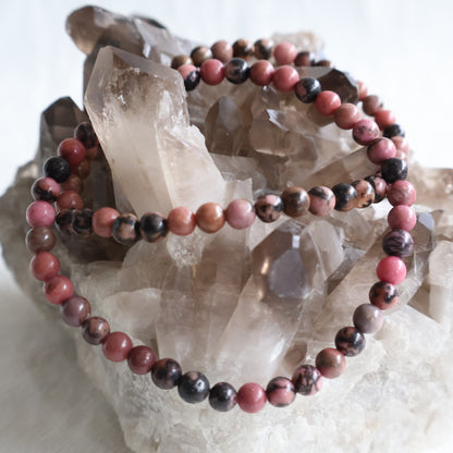 Natural Rhodonite 4mm crystal bead bracelet featuring soft pink tones with natural black manganese veining on a stretch cord.