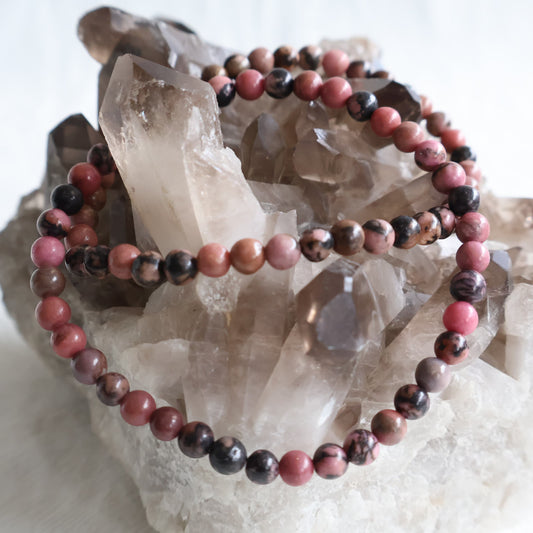 Natural Rhodonite 4mm crystal bead bracelet featuring soft pink tones with natural black manganese veining on a stretch cord.