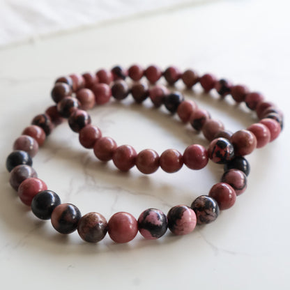 Rhodonite 6mm crystal bead bracelets with natural pink and dark manganese patterning.