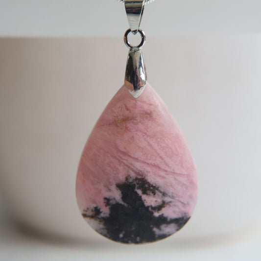 Rhodonite crystal pendant with soft pink tones and natural dark veining, exact piece shown