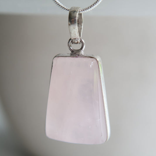 Rose quartz crystal pendant with soft pink tones and wrapped s925 silver border, exact piece shown