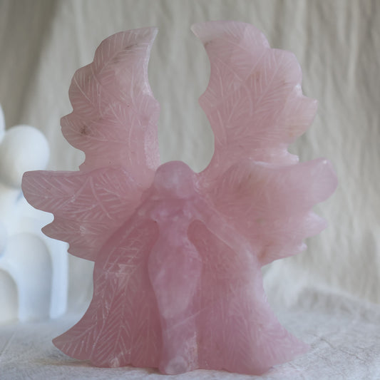 Large Rose Quartz angel crystal carving, 12cm tall and 11cm wide, with detailed feathered wings.