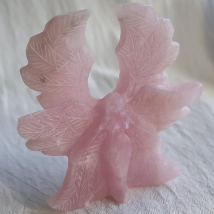 Large Rose Quartz angel crystal carving, 12cm tall and 11cm wide, with detailed feathered wings.