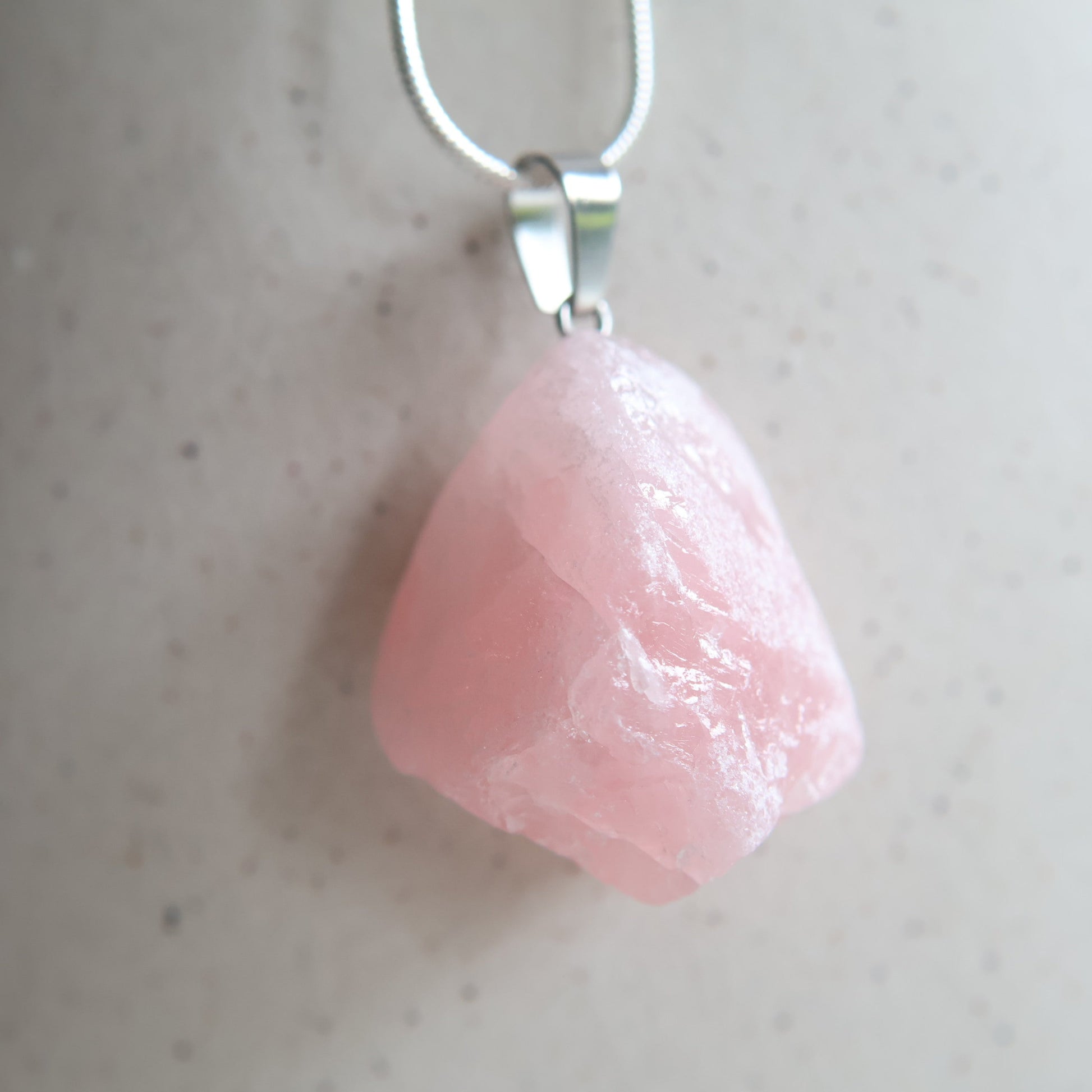 Raw rose quartz crystal pendant with natural pink tones, intuitively chosen