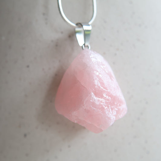 Raw rose quartz crystal pendant with natural pink tones, intuitively chosen
