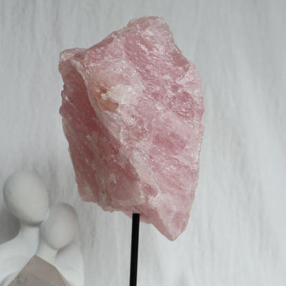Large 1.1kg raw Rose Quartz crystal on black rotating stand with natural soft pink colouring and raw texture, standing 24cm tall.