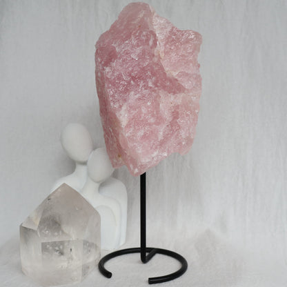 Large 1.1kg raw Rose Quartz crystal on black rotating stand with natural soft pink colouring and raw texture, standing 24cm tall.