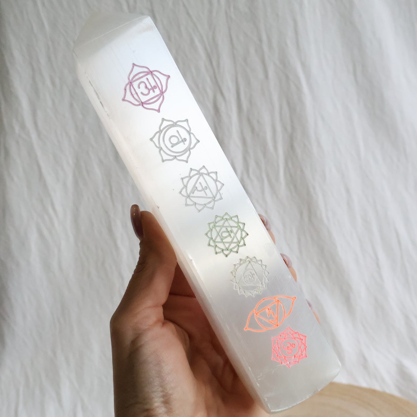 Large white Satin Spar crystal tower engraved with seven coloured chakra symbols from root to crown.