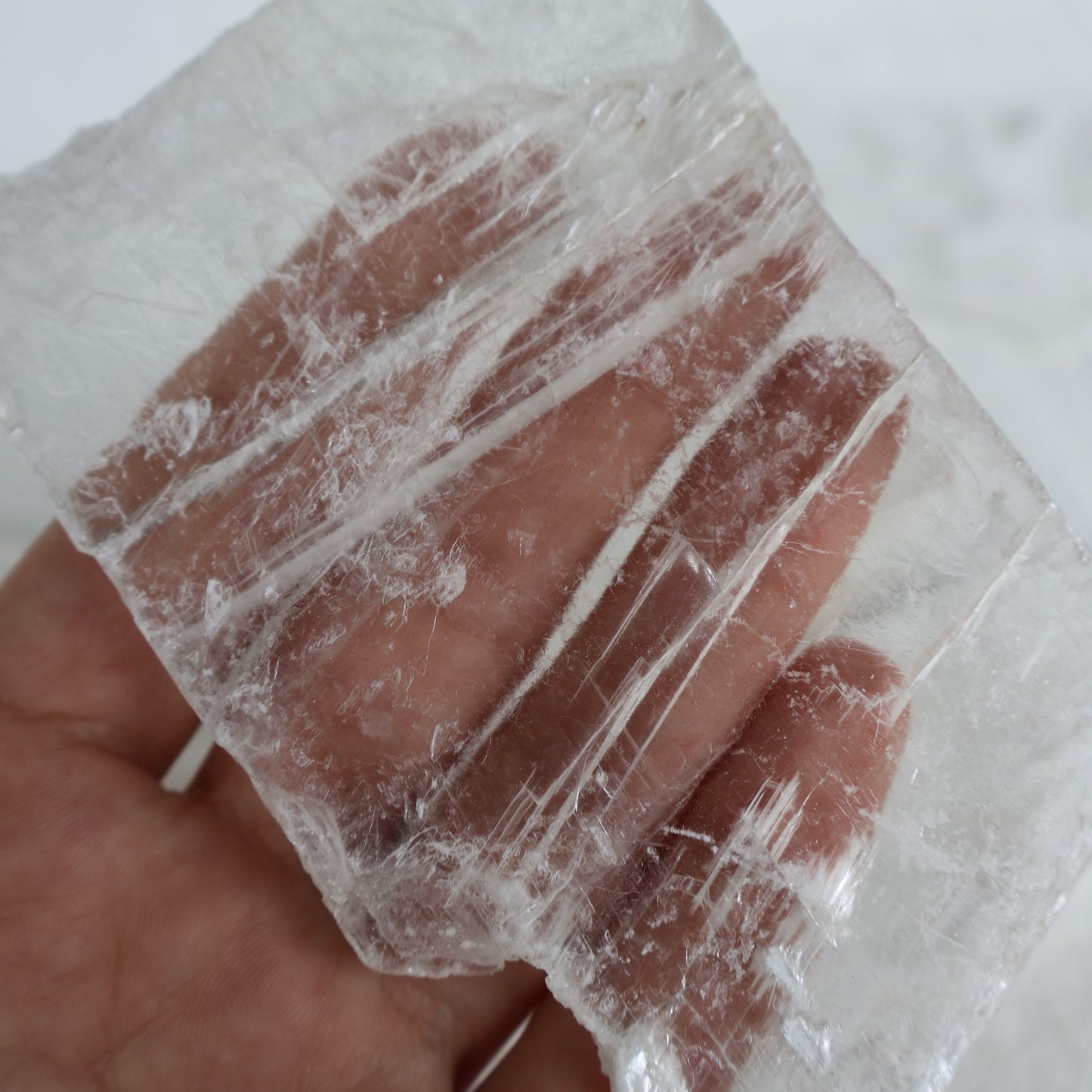 Hand holding a translucent block with visible veins