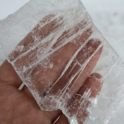 Hand holding a translucent block with visible veins