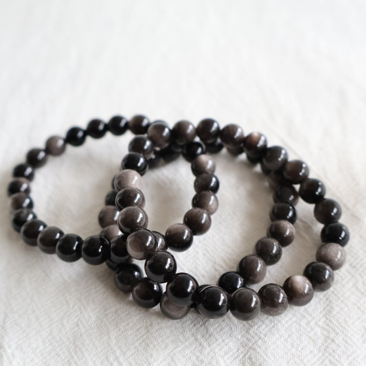 Silver Sheen Obsidian crystal bracelet with polished 8mm round beads on a stretch fit band.