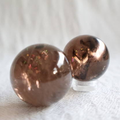 High-quality 3cm Smoky Quartz mini spheres with polished finish, natural inclusions and internal rainbow flashes.