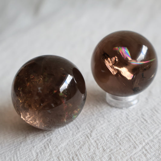 High-quality 3cm Smoky Quartz mini spheres with polished finish, natural inclusions and internal rainbow flashes.