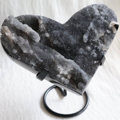 Large Sphalerite druzy crystal heart with dark charcoal-grey sparkling crystal formations displayed on a black metal stand.