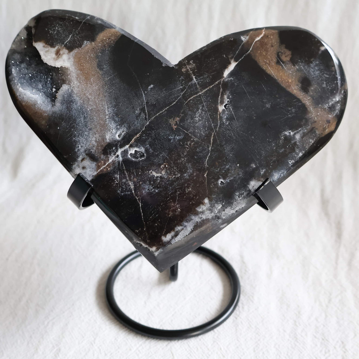 Large Sphalerite druzy crystal heart with dark charcoal-grey sparkling crystal formations displayed on a black metal stand.