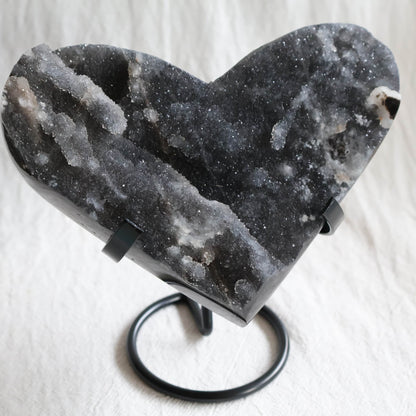 Large Sphalerite druzy crystal heart with dark charcoal-grey sparkling crystal formations displayed on a black metal stand.