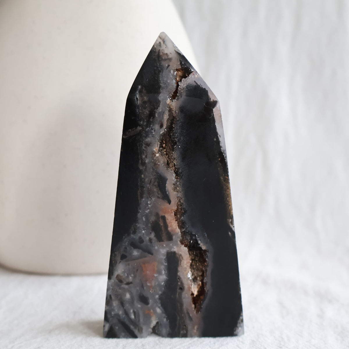 Sphalerite crystal obelisk with polished dark surfaces and natural druzy crystal pockets, measuring 11cm tall and weighing 196g.