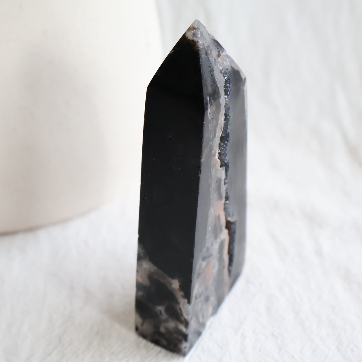Sphalerite crystal obelisk with polished dark surfaces and natural druzy crystal pockets, measuring 11cm tall and weighing 196g.