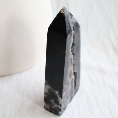 Sphalerite crystal obelisk with polished dark surfaces and natural druzy crystal pockets, measuring 11cm tall and weighing 196g.
