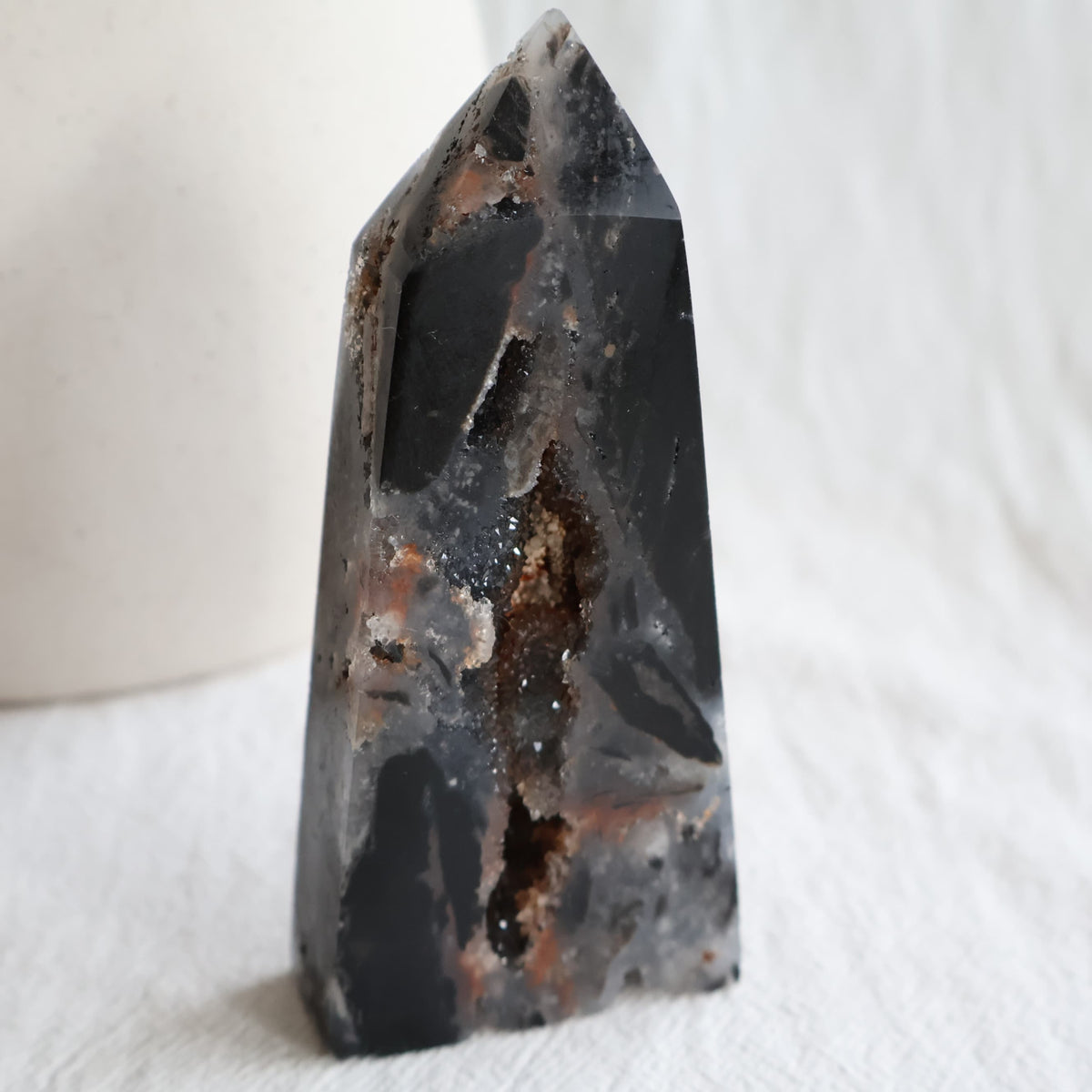 Sphalerite crystal obelisk with polished dark surfaces and natural druzy crystal pockets, measuring 11cm tall and weighing 196g.