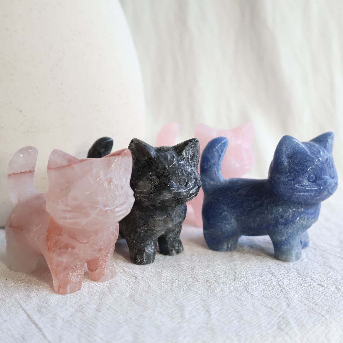 Medium standing cat crystal carvings in Rose Quartz, Fire Quartz, Blue Aventurine and Larvikite, approximately 5cm tall.