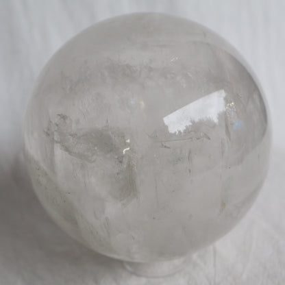 Large White Calcite sphere with soft white colouring, natural inclusions and internal rainbow flashes, 10cm diameter and weighing 1.624kg.