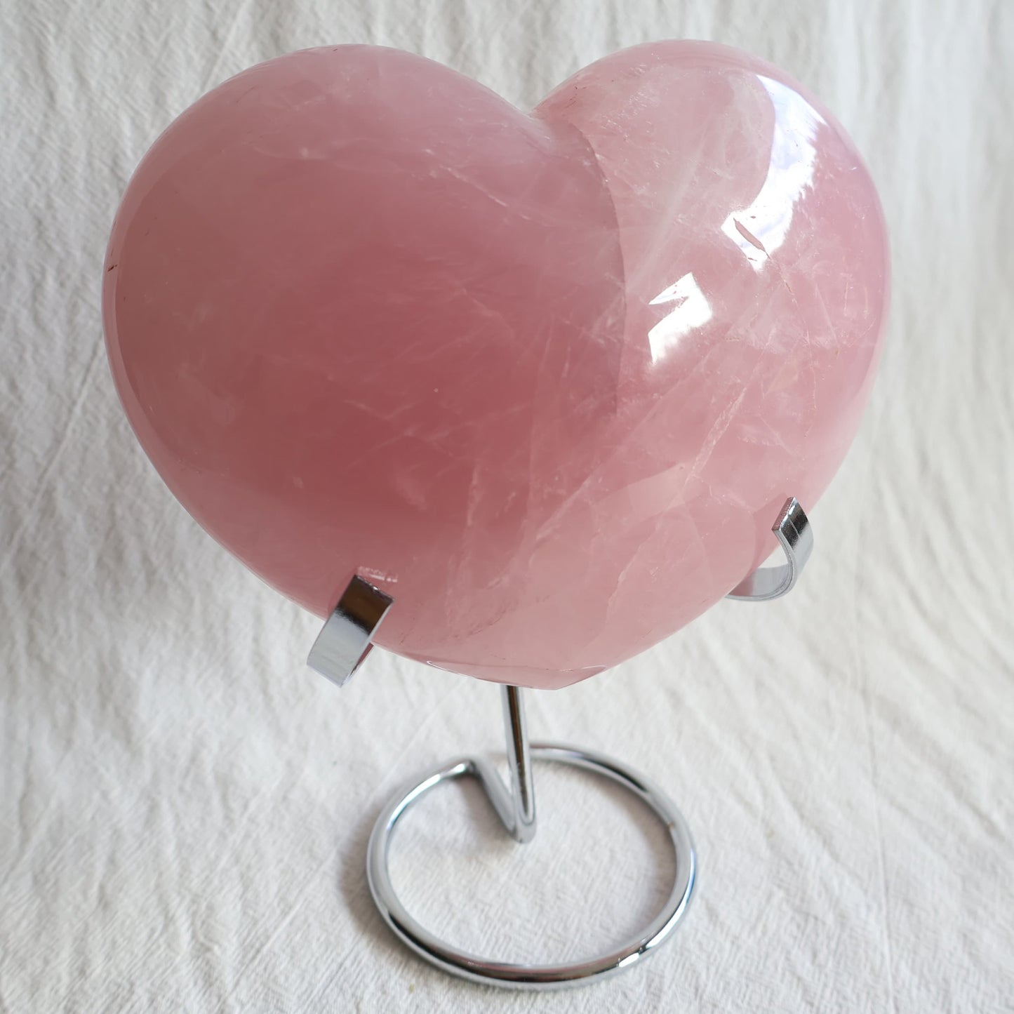XXL rose quartz puffy heart crystal on stand with soft blush pink colouring, natural clouding and polished finish.