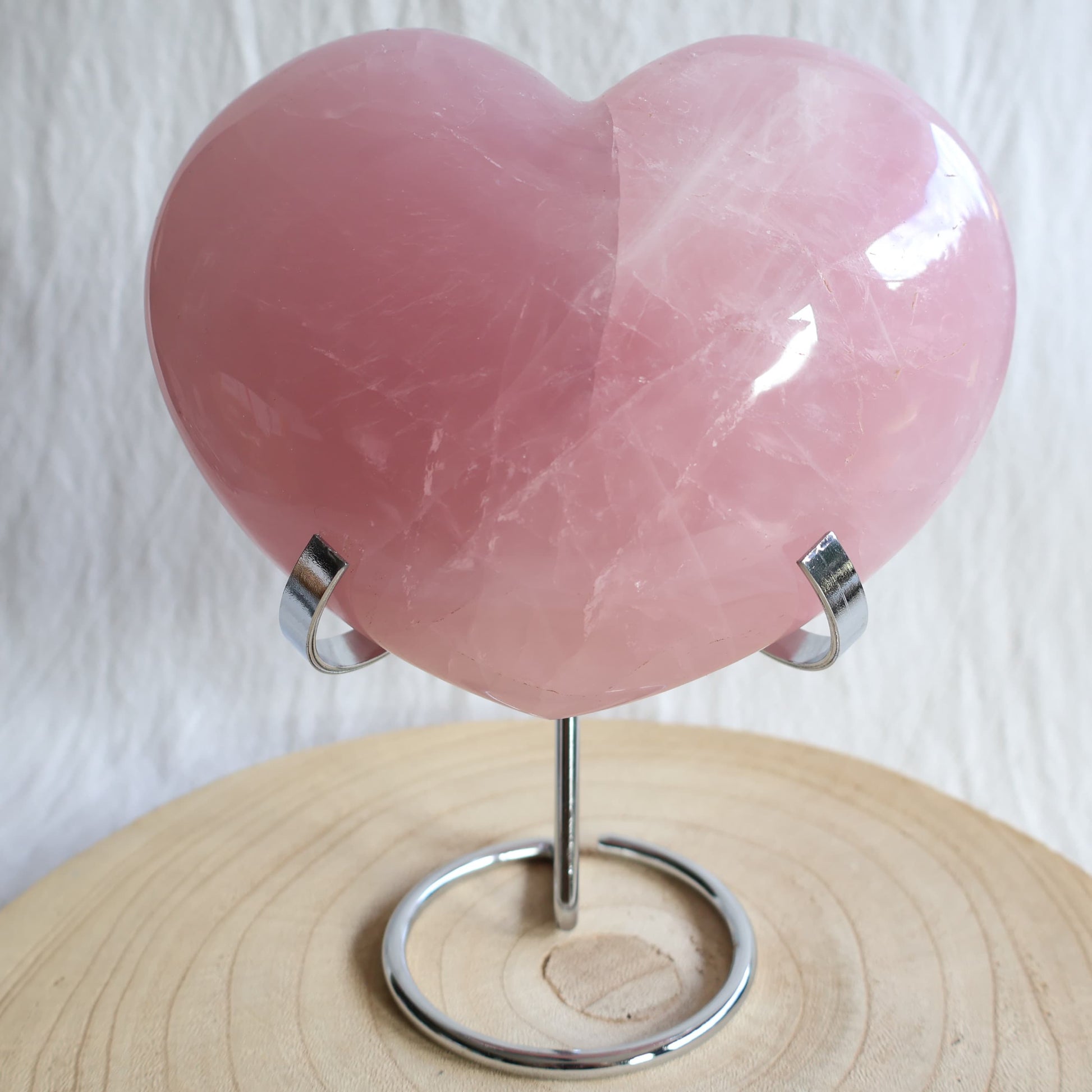 XXL rose quartz puffy heart crystal on stand with soft blush pink colouring, natural clouding and polished finish.