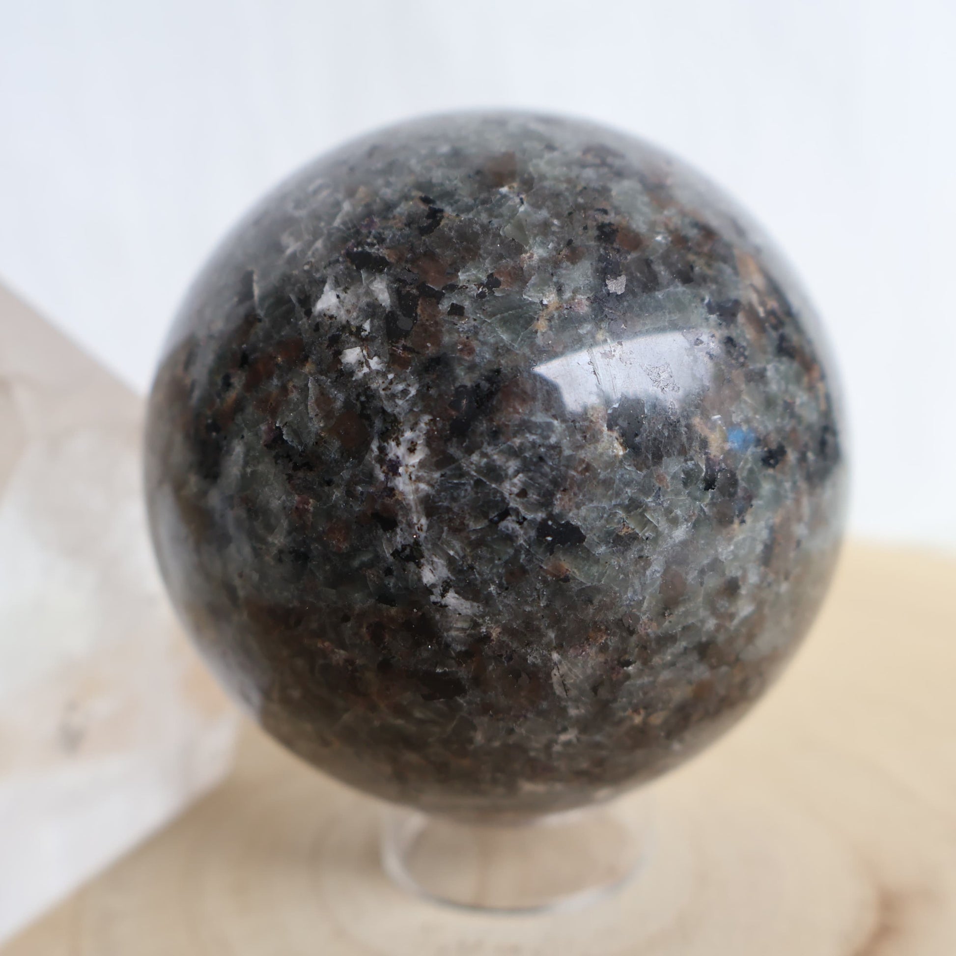 Yooperlite sphere measuring 7.5cm with natural grey speckled colouring and fluorescent sodalite that glows fiery orange under UV light.