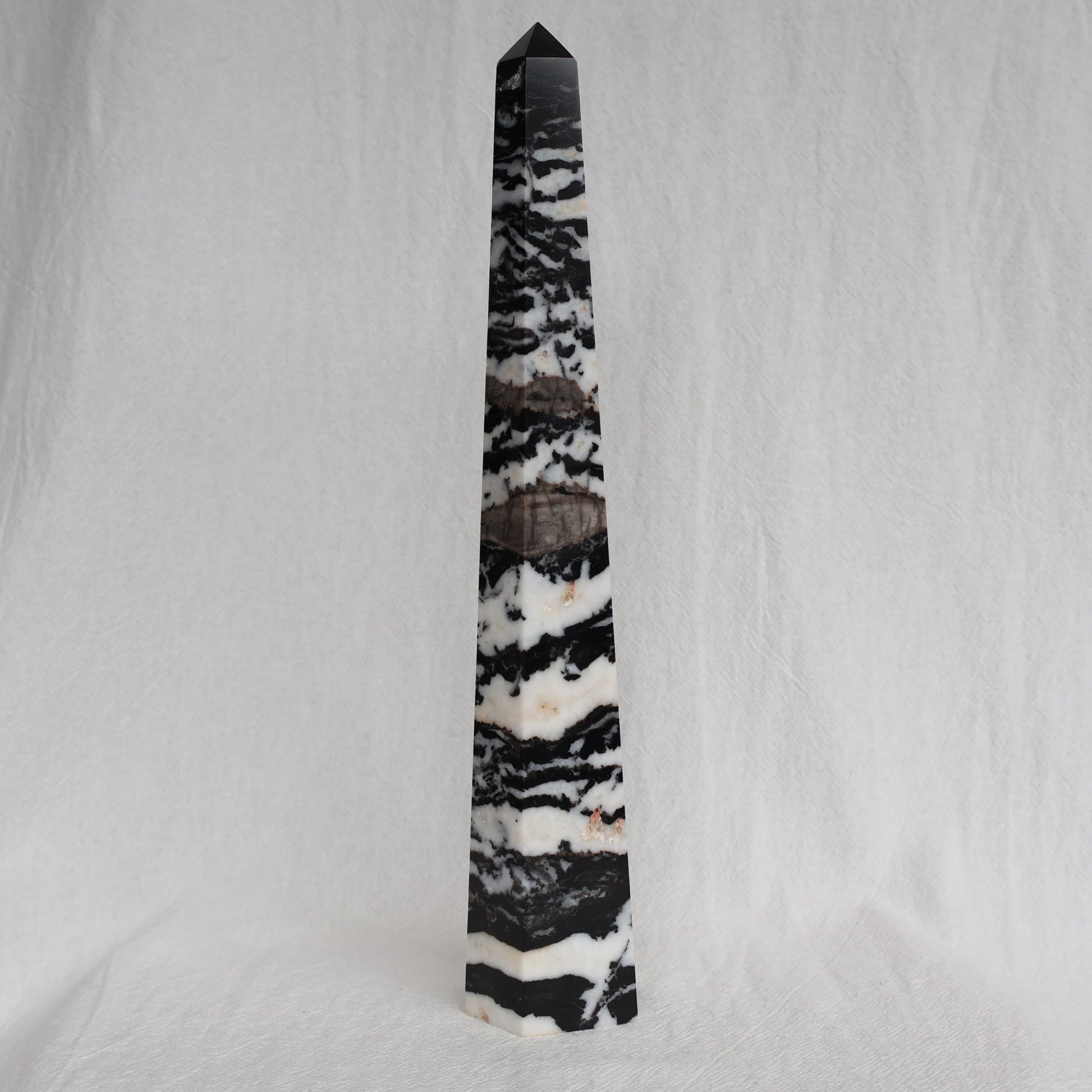 Large Zebra Jasper six-sided obelisk tower with bold natural black, white and grey patterning, standing 25cm tall and weighing 619g.