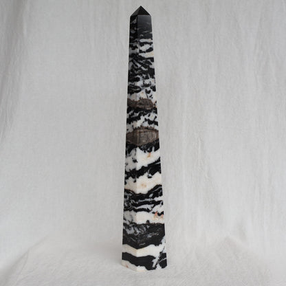 Large Zebra Jasper six-sided obelisk tower with bold natural black, white and grey patterning, standing 25cm tall and weighing 619g.