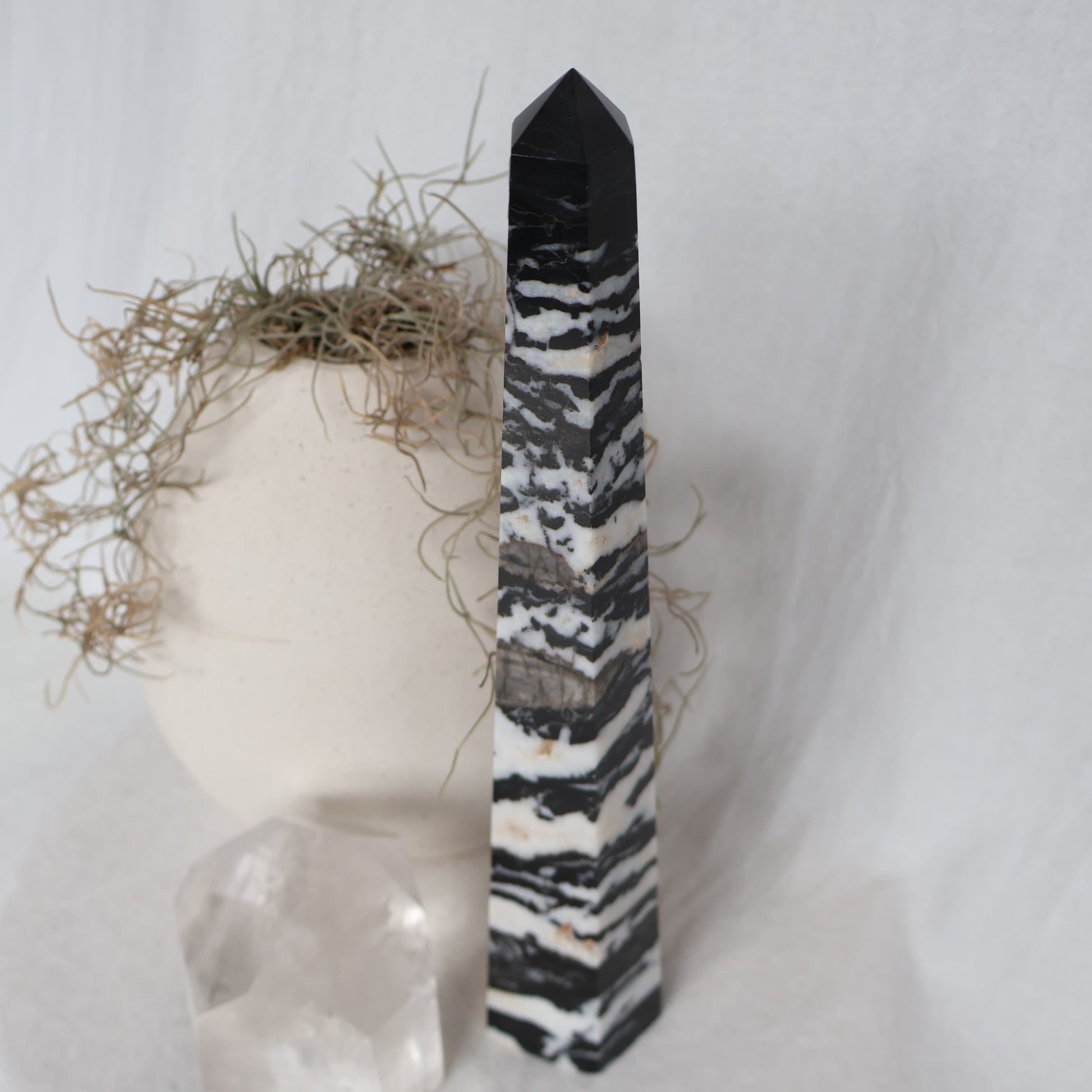 Large Zebra Jasper six-sided obelisk tower with bold natural black, white and grey patterning, standing 25cm tall and weighing 619g.