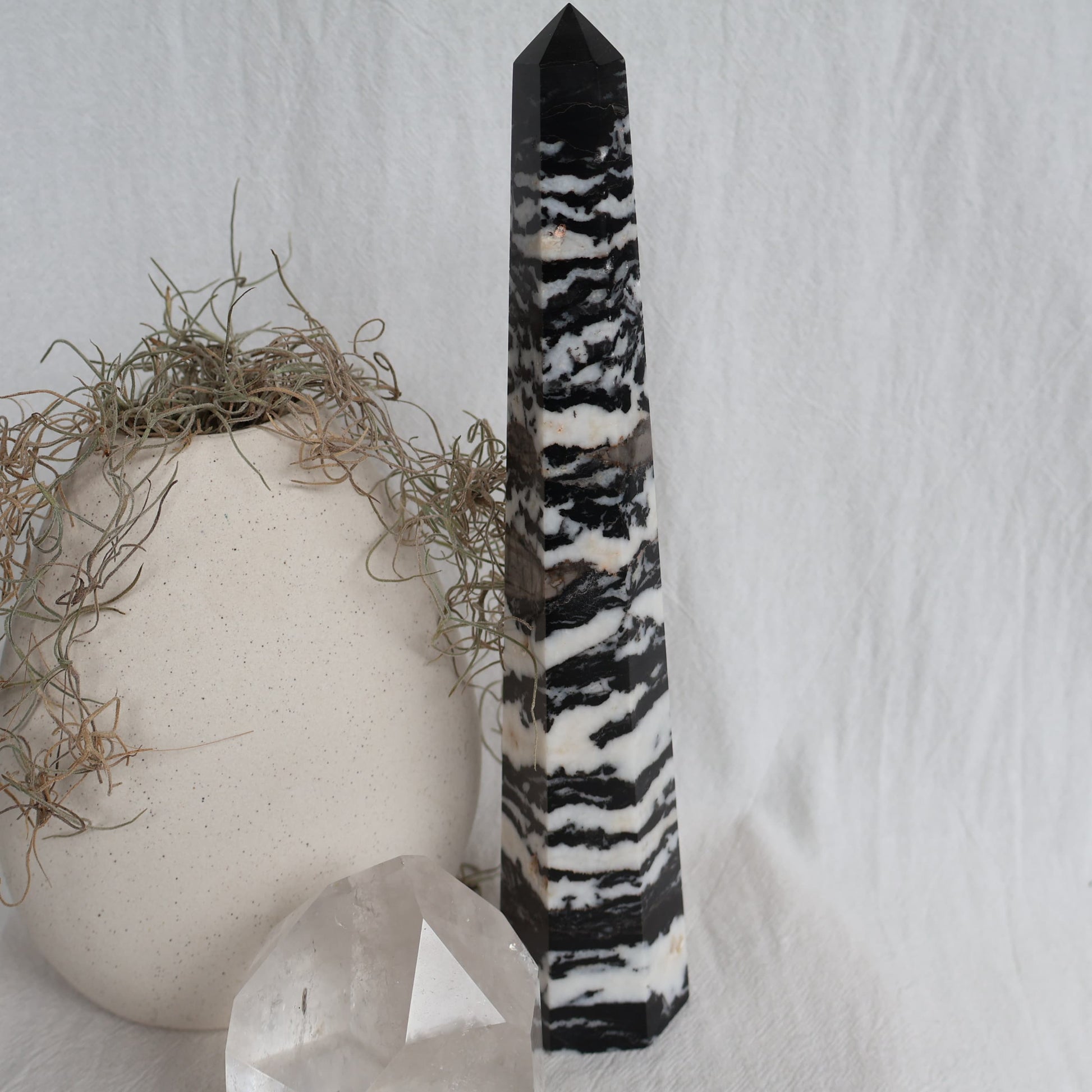 Large Zebra Jasper six-sided obelisk tower with bold natural black, white and grey patterning, standing 25cm tall and weighing 619g.